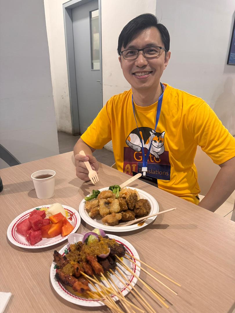 Nuestro amigo David Wang disfrutando del satay en la WordCamp Malasia 2025